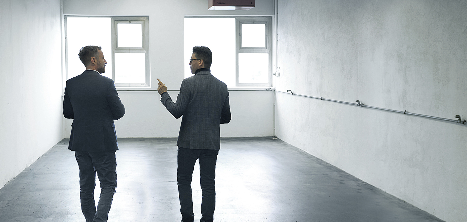 Jannis Rotar und Johannes Fiedler diskutieren in einer Gewerbehalle