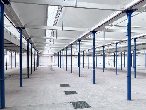 Innenansicht der Großen Halle. Historische Produktionshalle mit vielen blauen Säulen