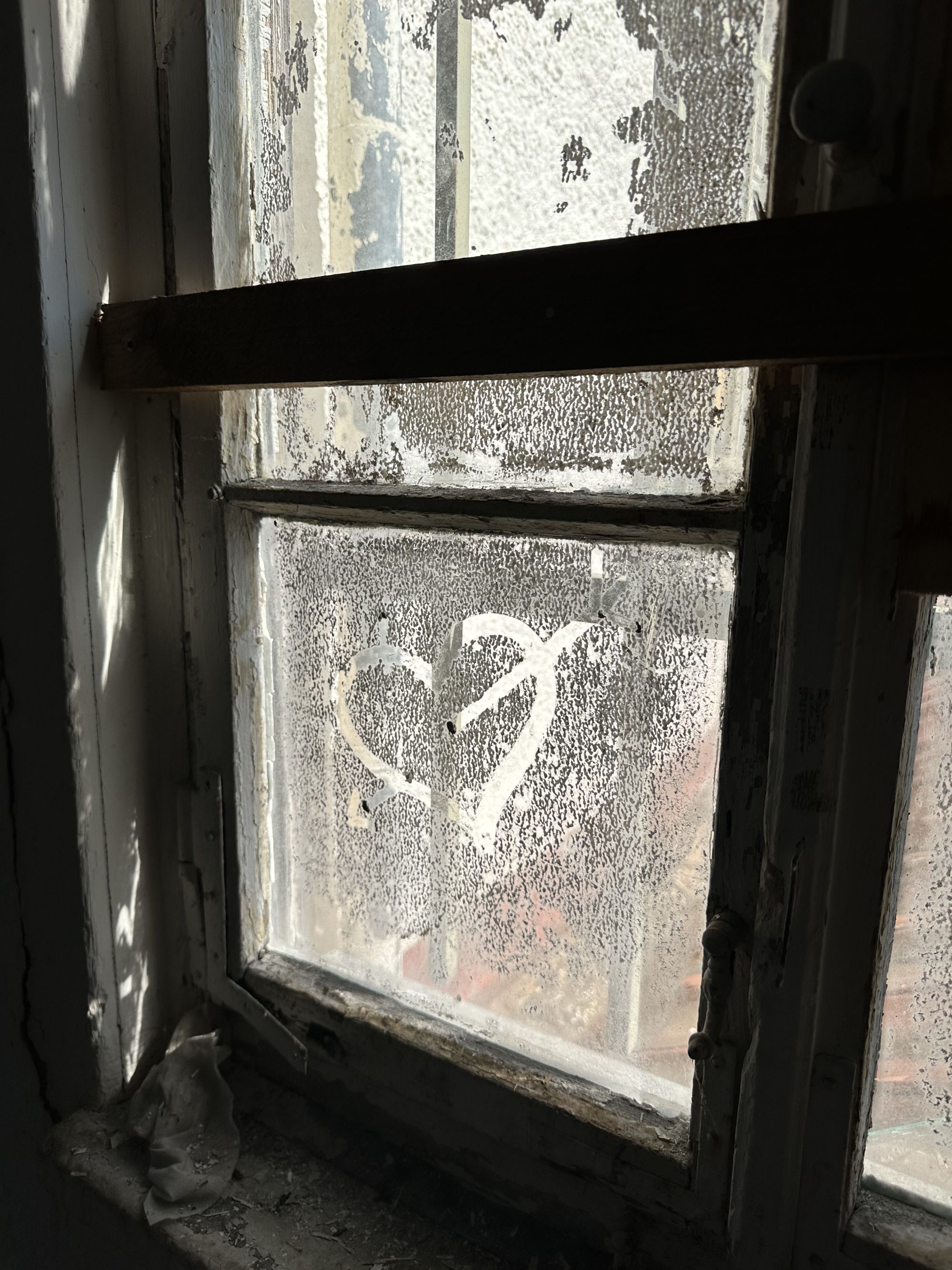 Ein eingestaubtes Fenster. In den Staub ist ein Herz eingeschrieben
